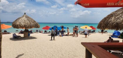 A breathtaking view of Arashi Park and Beach in Aruba, featuring pristine white sand, turquoise water, and a clear sunny sky.